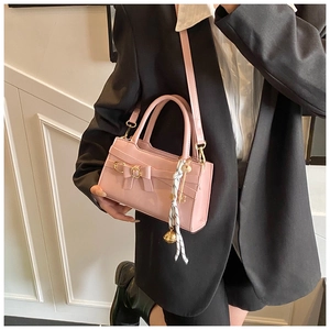 Hellrosa rechteckige Handtasche mit dekorativer Schleife und gestreiftem Schal am Griff
