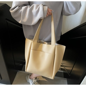 Detail of minimalist beige tote bag with smooth texture and long shoulder straps