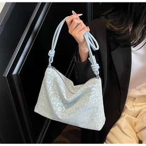 Détail du sac à bandoulière bleu clair avec motifs géométriques blancs et anses en corde