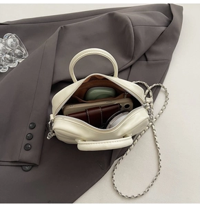 Top view of open white bowling bag showing storage for phone, wallet and makeup accessories