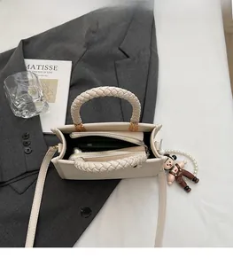 Interior view of beige crossbody bag with large capacity, zipper pocket, and pearl charm