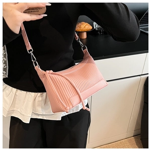 Gros plan du sac bandoulière rose clair avec texture plissée et détails argentés