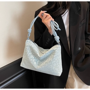 Détail du sac fourre-tout bleu clair en similicuir avec motifs abstraits et anse nouée