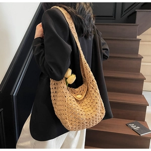 Detail view of khaki knit tote bag with hollow crochet pattern and wooden button closure