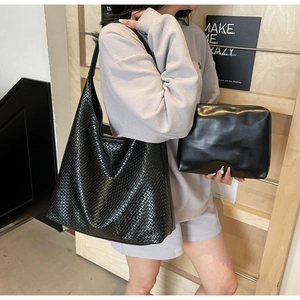 Detail of black woven hobo tote bag and matching leather pouch for women fashion