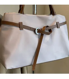 Close-up of lightweight nylon tote bag with brown leather strap and silver metal buckle