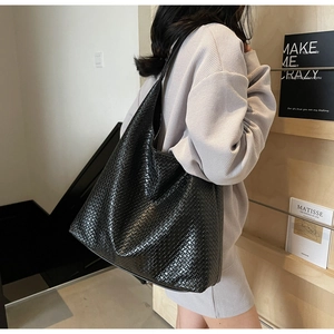 Close-up of classic black woven leather tote bag texture with large capacity design