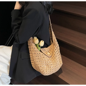 Detail of hollow knit hobo bag with flap closure and decorative flowers for vacation