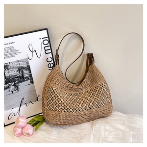 Detail of woven straw hobo bag with white diamond hollow pattern and brown leather strap