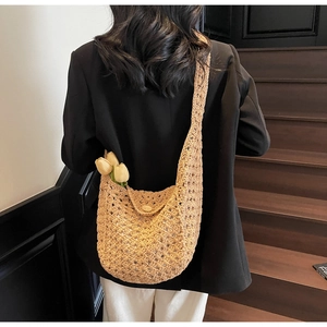 Detail of beige crochet hollow knit shoulder bag with a round button closure