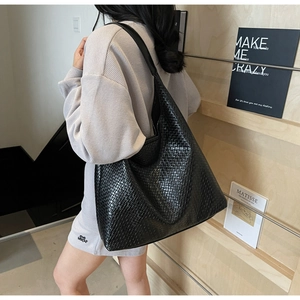 Detailed view of black woven tote bag showing fine texture and large capacity