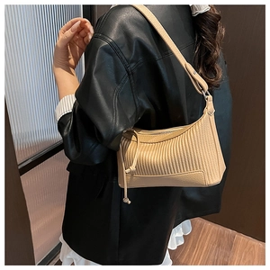 Détail du sac croissant plissé beige avec grain vertical doux et bandoulière large