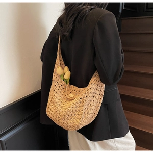Detail of hand-crocheted hollow knit shoulder bag with wood button and flower decoration
