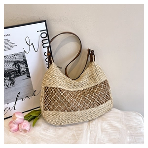Close-up of woven hollow shoulder bag with brown leather strap on elegant white fabric