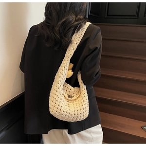 Detail der hohlgehäkelten cremefarbenen Hobo-Tasche mit Vintage-Knopf und breitem Schultergurt