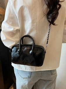Glossy black leather bowling bag with silver chain strap and top handles for women
