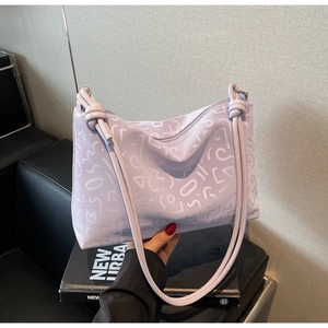 Détail d'un sac lavande avec imprimés abstraits et bandoulière à nœud décoratif