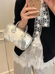 Metallic silver leather bowling bag with chain strap shown in mirror selfie