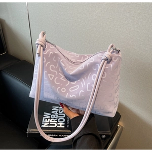 Détail du sac cabas lilas avec motifs géométriques blancs et bandoulière à nœuds