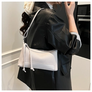 Gros plan sur le sac blanc plissé avec texture grainée sur un mannequin en veste cuir