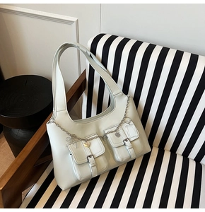 Detail of mint green PU leather shoulder bag with buckle pockets and heart chain charm