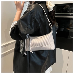 Détail du sac à bandoulière blanc à texture litchi avec décoration de nœud à franges
