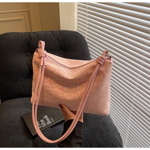 Détail du sac en similicuir rose avec motifs en relief 3D et bandoulière à nœud décoratif