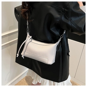Détail du sac bandoulière crème avec texture plissée verticale et nœud coulissant