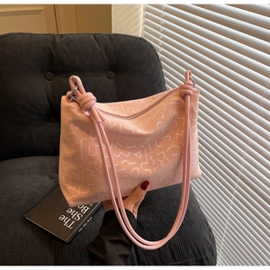 Détail du sac fourre-tout rose avec gaufrage géométrique et doubles brides nouées