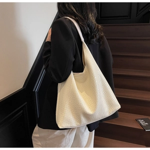 Detail of the woven leather texture and large capacity on this cream white tote bag