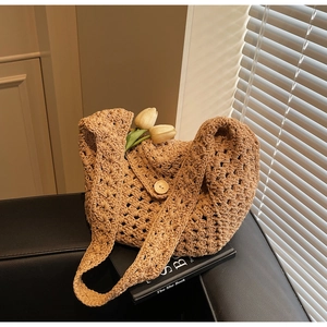 Detail of hollow knit tote bag with wooden button closure and decorative tulips