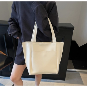 Close-up of beige PU leather tote bag with large front pocket and precise stitching detail
