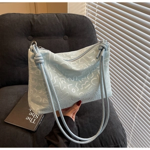 Détail du sac cabas bleu clair avec gaufrage géométrique abstrait sur cuir synthétique