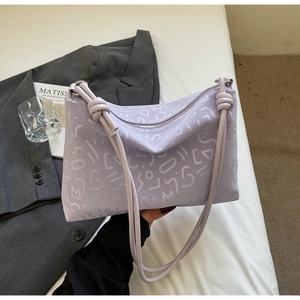 Détail d'un sac cabas lavande avec bandoulière nouée et imprimé de lettres artistiques