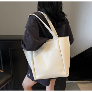 Detail view of large cream PU leather tote bag with functional front pocket for daily use