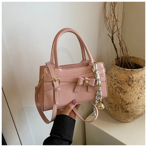 Detail der rosa Lackleder-Handtasche mit Schleifendekor und schickem Seidentuch-Accessoire
