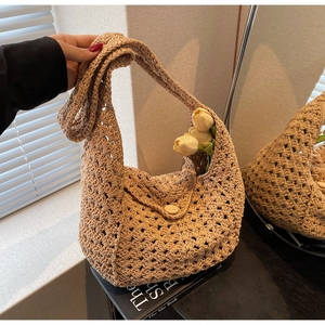 Detailed close-up of a beige crochet knit bag with intricate openwork and wooden button