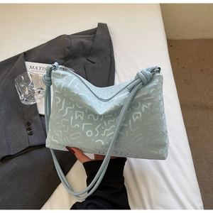 Détail du sac à bandoulière bleu clair avec relief géométrique et design à nœuds élégants