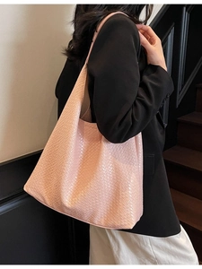 Pink woven leather tote bag with large capacity shown on a model in a hobo style