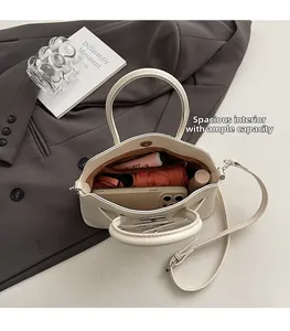 Vista interna che mostra la capiente borsa in pelle color crema con oggetti essenziali