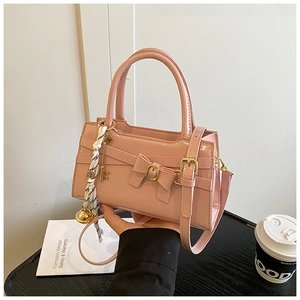 Detail der hellrosa Lackledertasche mit Schleifenschnalle und dekorativem Schalgriff