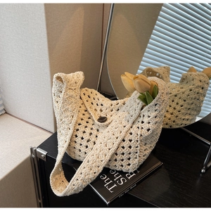 Close-up of beige crochet knit bag with intricate hollow texture and wooden button closure