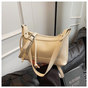 Détail du sac crème en cuir grainé avec matelassage vertical et bandoulière réglable