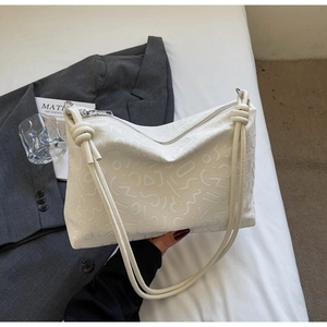 Détail du sac cabas blanc avec motifs abstraits en relief et fines bandoulières nouées