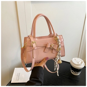 Detail einer rosa Lackleder-Handtasche mit Schleife und kariertem Seidentuch am Griff
