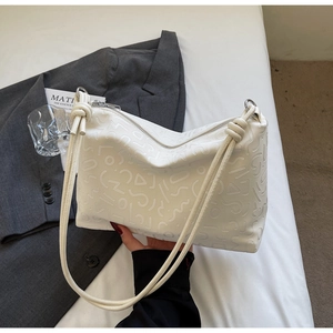 Détail du sac cabas blanc avec motifs géométriques en relief et fines bandoulières
