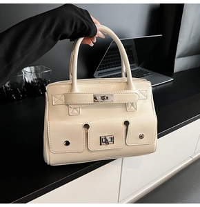 Detail of off-white leather handbag with functional pockets and silver buckle closure