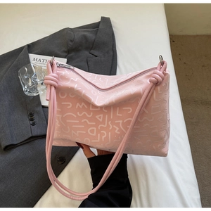 Détail du sac cabas rose avec texture géométrique gaufrée et bandoulière nouée