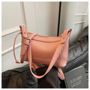 Détail du sac à main en cuir rose avec texture litchi et design plissé vertical
