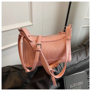 Détails de la texture en cuir litchi rose et des plis verticaux du sac à bandoulière